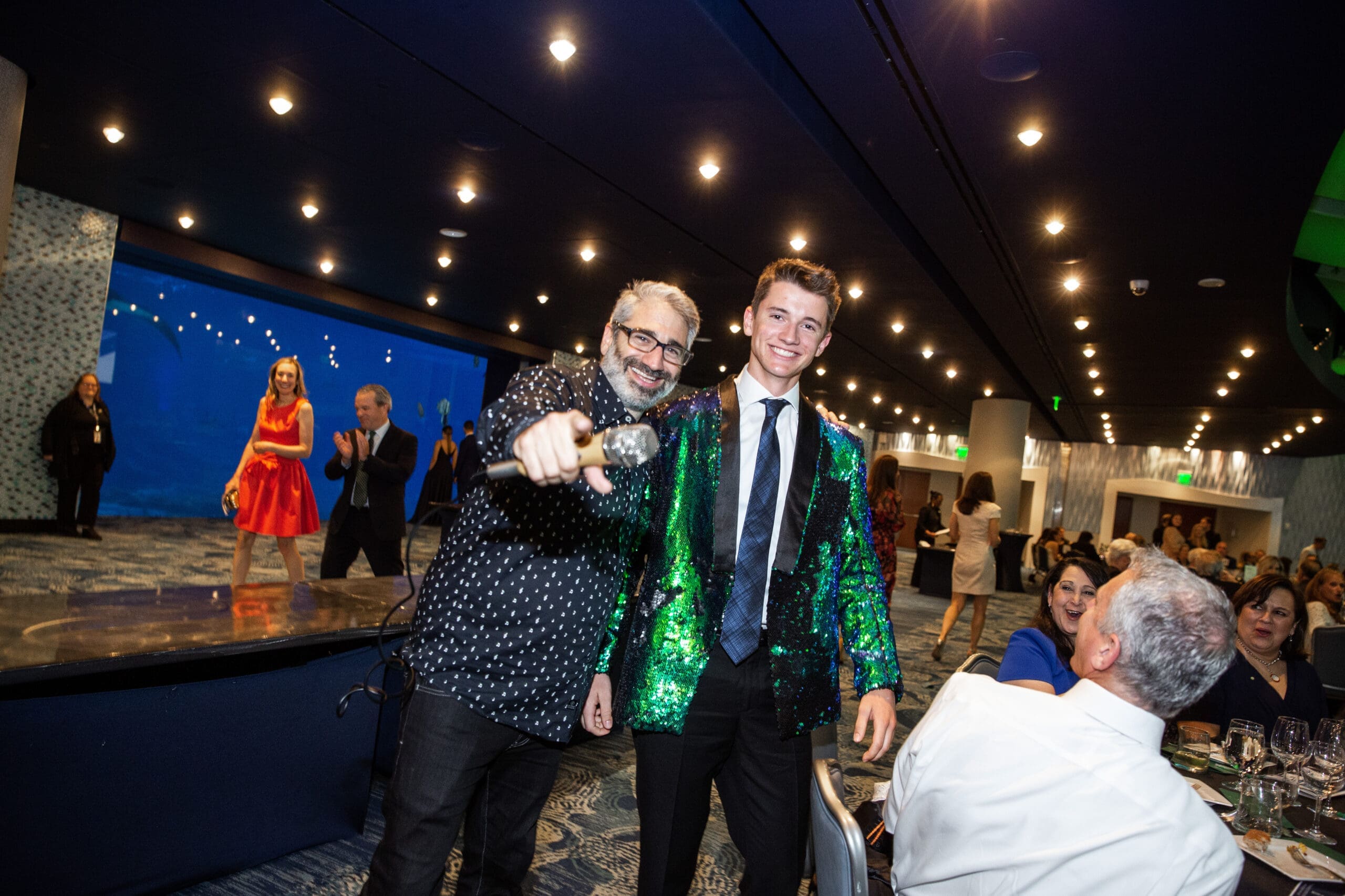 Man with a microphone pointing towards a camera